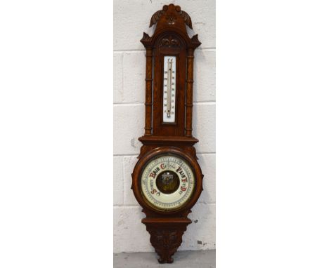 A late 19th-early 20th century carved oak barometer and thermometer backed on white glass, height 95cm.