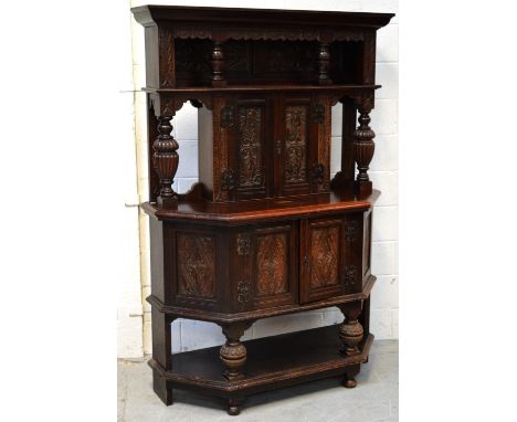 An early 20th century carved oak shaped court cupboard with galleried plate rack over small two-door cupboard over shelf, wid