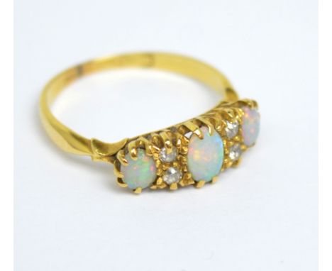 An 18ct yellow gold ring set with three oval opals and four small diamonds, sixe K, approx 2.1g.