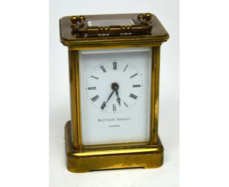 A Matthew Norman brass carriage clock, white enamel dial set with Roman numerals, marked Matthew Norman London to front, in o
