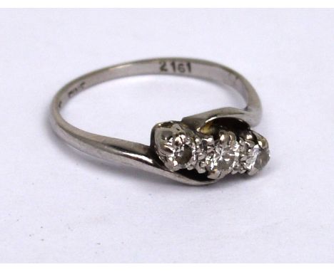 An 18ct white gold three-stone cross-over diamond ring, size K, approx 2.5g.