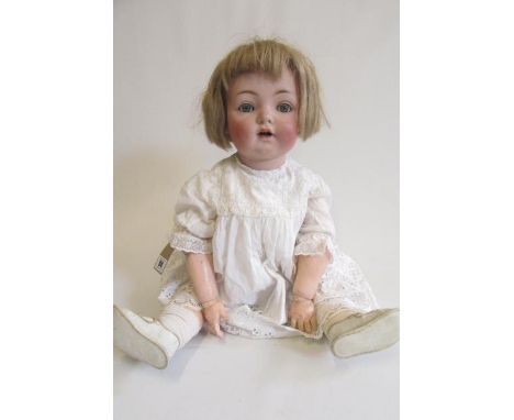 A Kammer &amp; Reinhardt bisque socket head doll, with blue glass sleeping eyes, open mouth, trembling tongue, blonde wig, jo