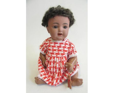 A Kammer &amp; Reinhardt bisque socket head doll, with brown glass sleeping eyes, open mouth with two top teeth, trembling to