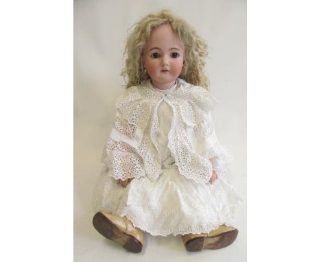 A Kammer &amp; Reinhardt bisque socket head doll with brown glass sleeping eyes, open mouth with four top teeth, pierced ears