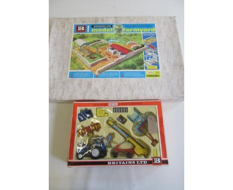 A Britains 4711 model farmyard, in original cardboard box, 25 1/2" x 17 1/2", together with a Farm Tractor and Implements set