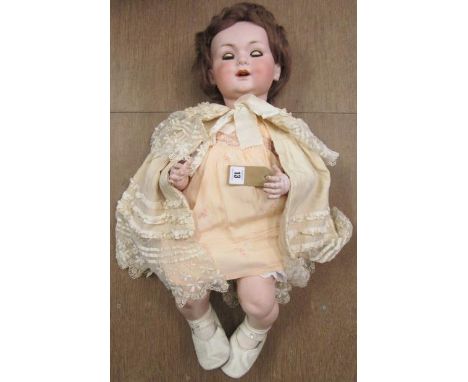 An Armand Marseille bisque socket head doll with brown glass sleeping eyes, open mouth with two moulded upper teeth, nylon wi