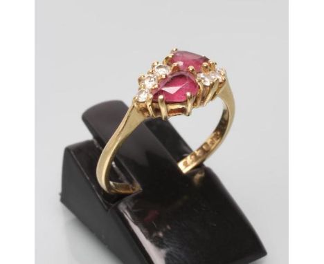 A RUBY AND DIAMOND RING, the two tear cut rubies point set and flanked by two sets of three small round brilliants to a plain