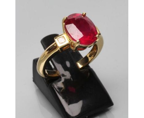 A RUBY RING, the oval facet cut stone of approximately 5.1cts claw set to square shoulders each with a small Princess cut dia