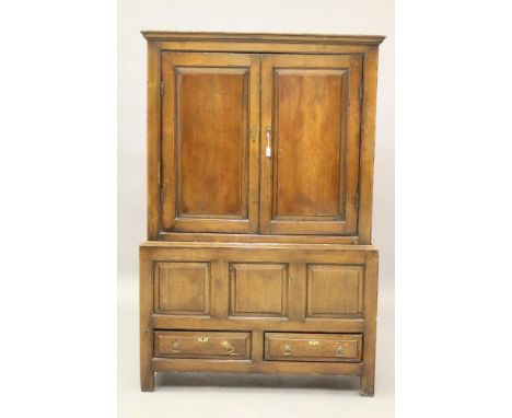 A GEORGIAN PINE PANELLED CLOTHES CUPBOARD, 18th century, the moulded cornice over a pair of fielded panel doors enclosing a h