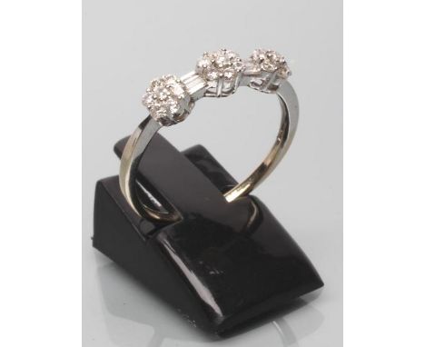 A DIAMOND TRIPLE CLUSTER RING, the three small flowerheads each point set with seven small round brilliants, each with a pair