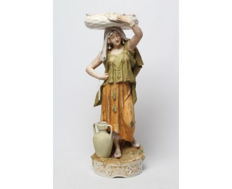 A LARGE ROYAL DUX PORCELAIN FIGURE, early 20th century, modelled as a young woman carrying a flat basket on her head, wearing