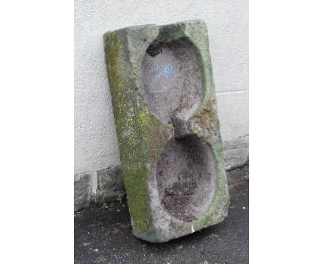 A SANDSTONE TROUGH of fine cut oblong form, the interior with two interconnecting bowls and cut outlet to one end, 39 1/2" x 