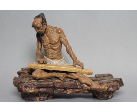 A CHINESE SHIWAN STONEWARE FIGURE, the seated ascetic with long pony tail, moustache and beard, wearing a grey glazed loin cl