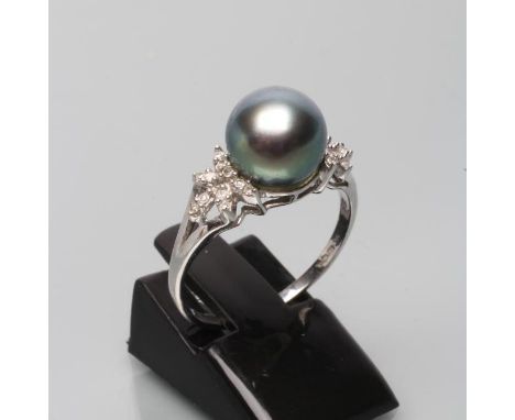 A BLACK TAHITIAN PEARL AND DIAMOND COCKTAIL RING, the peg set pearl to diamond set open bow shoulders and plain 18ct white go