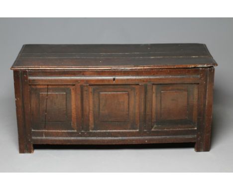 AN OAK PANELLED COFFER, early 18th century, the hinged plank lid with moulded edge, the fascia with three fielded panels, on 