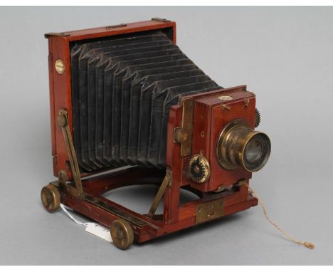 A THORNTON PICKARD "TRIBUNE" FIELD CAMERA of wooden construction with brass fittings and rectoplanat lens, 6" wide (Est. plus