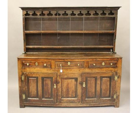 A GEORGIAN OAK DRESSER, early/mid 18th century, the boarded delft rack (reduced) with moulded cornice and pierced frieze over