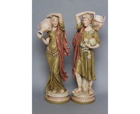 A PAIR OF ROYAL DUX PORCELAIN FIGURES, early 20th century, modelled as a young man holding a basket on his left shoulder, two