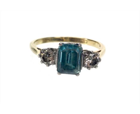 BLUE GEM SET AND DIAMOND RING, the step cut blue gem flanked by two round brilliant cut diamonds totalling approximately 0.30