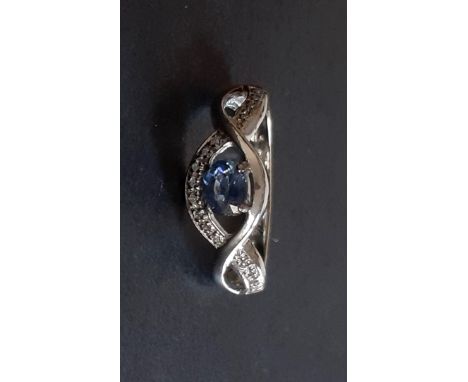 A 9ct white gold ring set with an oval cut tanzanite and diamonds, (L).