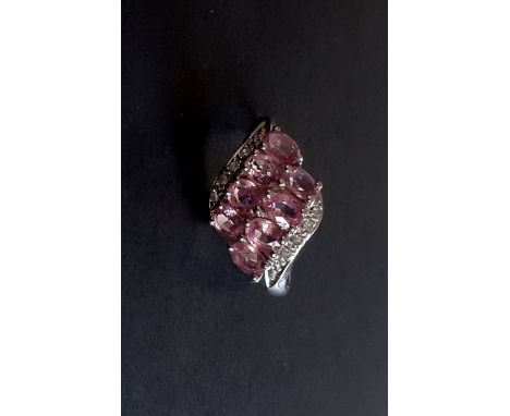 A 9ct white gold ring set with oval cut fancy pink sapphires and diamonds, (M.5).