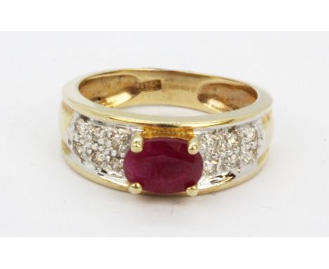 A 9ct yellow gold ring set with an oval cut ruby and diamonds, (L).