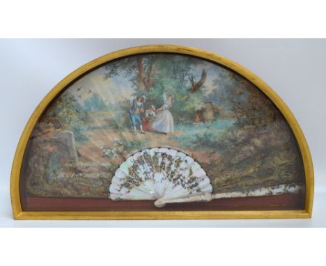 An early 19th century French folding fan, the mother of pearl shaped pierced guards inlaid with silver and gilt metal and dec