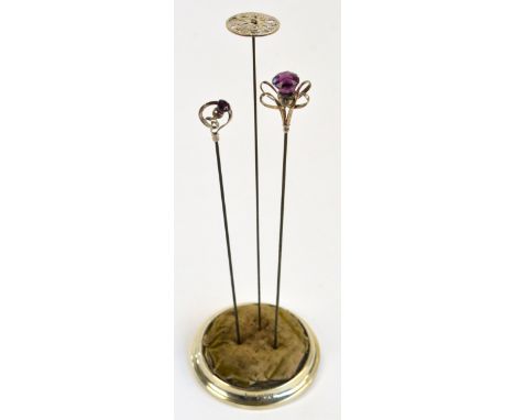 A Charles Horner hallmarked silver hat pin in the form of a thistle with an amethyst coloured glass flower and four corner lo