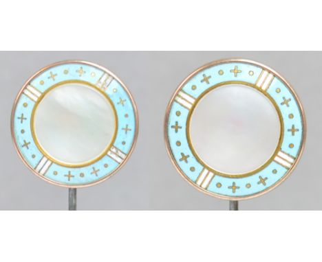 A pair of gilt metal circular hat pins with white and pale blue enamel rims set with crosses and dots and centred with a disc