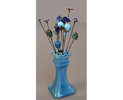 A collection of eighteen blue hat pins including a chinoiserie painted blue ground ovoid example, a pair of turquoise coloure