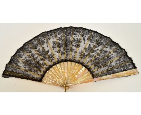 A late Victorian folding fan with plain mother of pearl guards and sticks, with pierced bone slips, with mother of pearl edge
