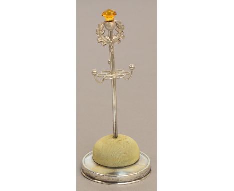 An Edward VII hallmarked silver hat pin stand in the form of a thistle with a citrine coloured glass flower with scrolled wir