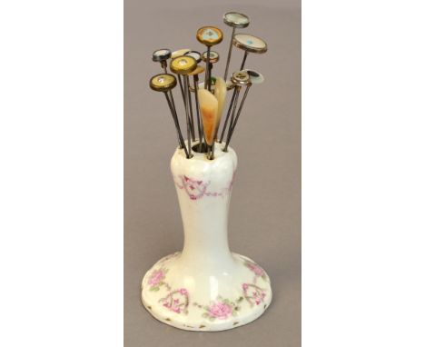 A collection of seventeen predominantly mother of pearl headed hat pins including a sterling silver rimmed example with disc 