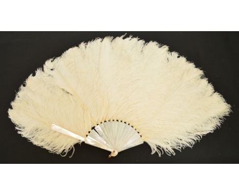 An ostrich feather fan with plain mother of pearl guards and sticks, with gilt metal loop, the leaf made up of dyed white ost