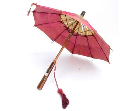A small Edwardian parasol with four tone cream and pink silk shade, with white metal mounted mahogany handle set with a mothe