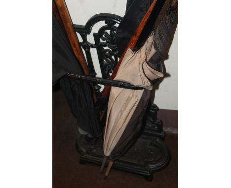 A CAST STICK STAND TOGETHER WITH A COLLECTION OF WALKING CANES AND UMBRELLAS