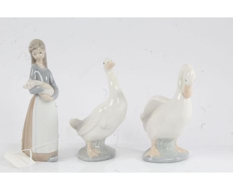 Lladro figure modelled as a young lady holding a piglet, 17cm high, two Nao ducks, 15cm and 14.5cm high (3)