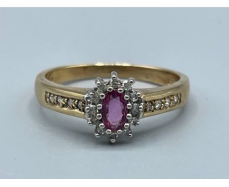 9ct gold ruby and diamond cluster ring comprising of oval ruby set surrounded by 12 round brilliant cut diamonds 2.69g size O