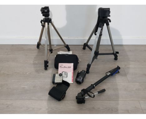 A lot to include three camera stands a cannon camera and a mini hand held video cam with power shot driver manual.