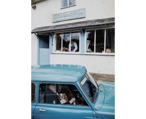 ‡JOHN BULMER (British, b.1938) colour photographic print circa 1960s - lady and spaniel in car outside of a butcher's shop D 