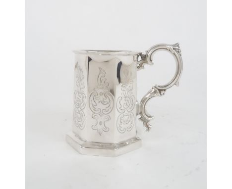 A VICTORIAN SILVER TANKARD of faceted form, with engraved scrolling foliate decoration to each panel, with a moulded rococo s