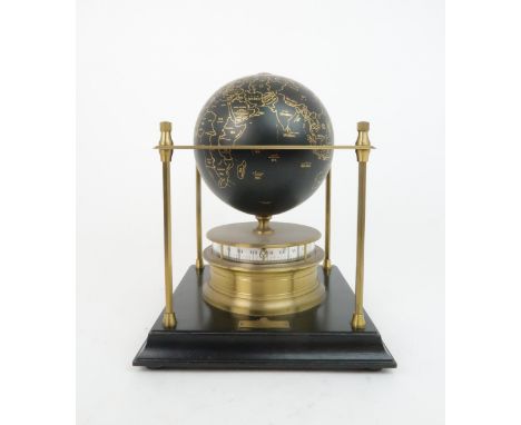 A ROYAL GEOGRAPHICAL SOCIETY WORLD CLOCK with rotating terrestrial globe and gilt metal chassis, upon an ebonized wooden base