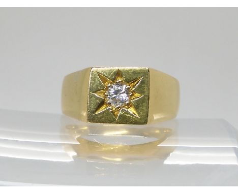 AN 18CT GOLD GENTS SIGNET RING set with a 0.20ct brilliant cut diamond in star burst setting. Hallmarked London 1976. finger 