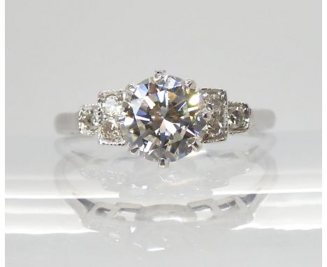 A CLASSIC DIAMOND SOLITAIRE RING set with an estimated approximately 1.05ct diamond, with further eight cut diamonds in millg