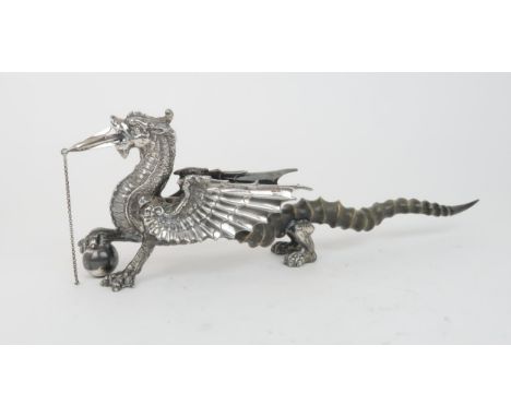 A VICTORIAN SILVER PLATED AND ANTELOPE HORN TABLE LIGHTER in the form of a winged dragon resting its hand on a flaming grenad