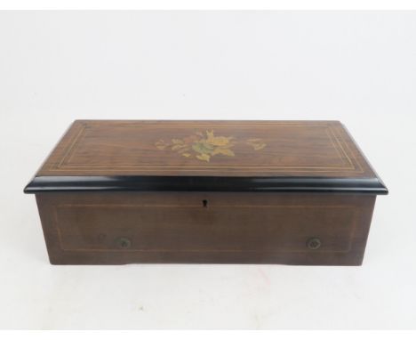 A CONTINENTAL MUSICAL BOX the rosewood veneered marquetry case enclosing a glazed cover above the movement, 41cm wide, 19cm d