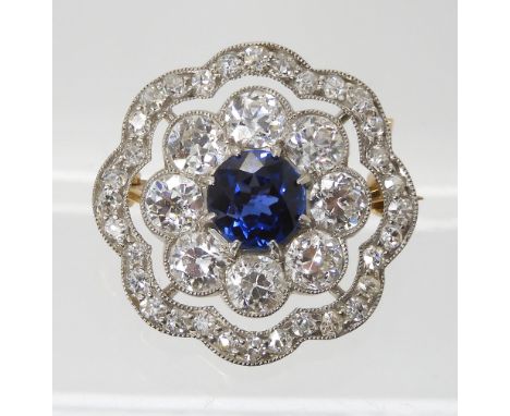 A SAPPHIRE AND DIAMOND BROOCH set with a mid blue sapphire approx diameter 6.1mm, surrounded with 0.15ct and 0.015ct old cut 