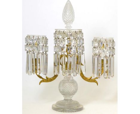 A Regency gilt metal and cut glass twin light candelabrum with pinecone finial the dish sconces hung with prismatic drops on 
