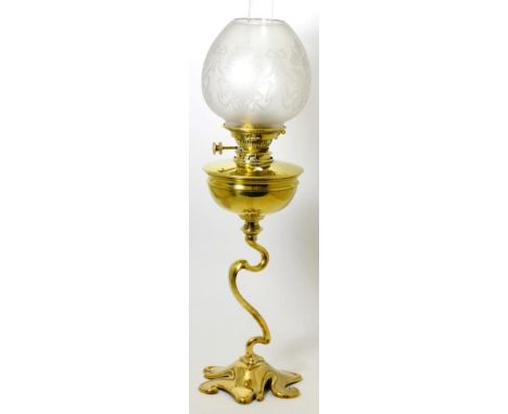 A Victorian brass oil lamp with etched glass shade and glass chimney, semi ovoid reservoir on a whiplash stem and scroll moul