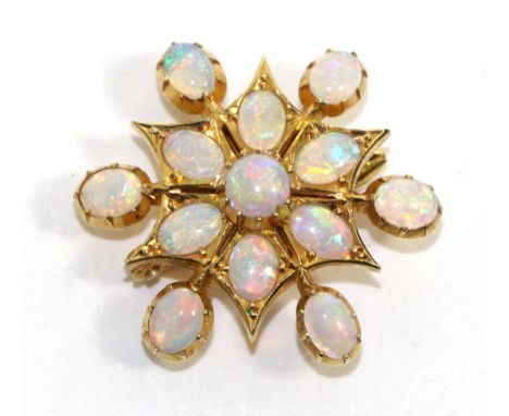 An opal star brooch/pendant, round and oval cut opals in yellow collet settings with six opal set radial arms, measures 2.7cm